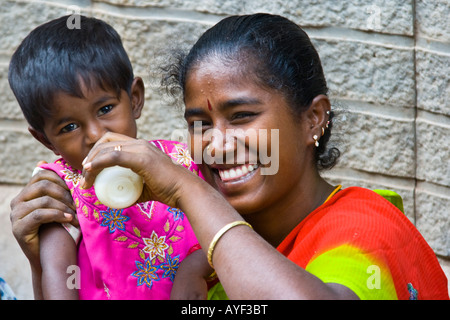 Mère Fille d'alimentation de la bouteille dans un marché à Madurai Inde du Sud Banque D'Images