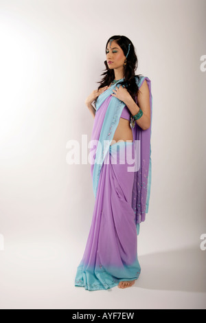 La tranquillité de la paix Inde Pakistan sari jeune femme portant robe indienne traditionnelle reste tranquille divinité fashion sari violet Banque D'Images