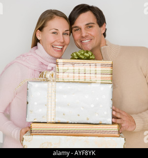 Couple holding pile of gifts Banque D'Images
