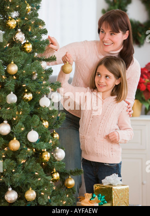 Mère et fille decorating Christmas Tree Banque D'Images