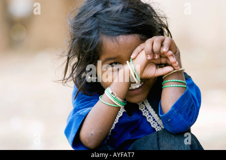 Pauvre petite fille indienne rire derrière ses mains Banque D'Images