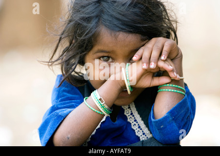 Pauvre petite caste inférieure Indian girl staring derrière ses mains. L'Andhra Pradesh, Inde Banque D'Images