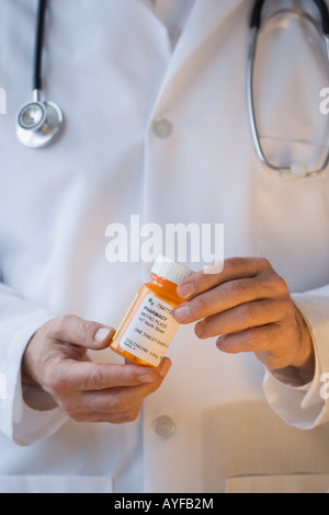 Doctor holding prescription bottle Banque D'Images