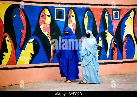 Les femmes musulmanes de porter le tchador traditionnel ou nikab devant une peinture murale représentant des femmes musulmanes au Maroc Banque D'Images