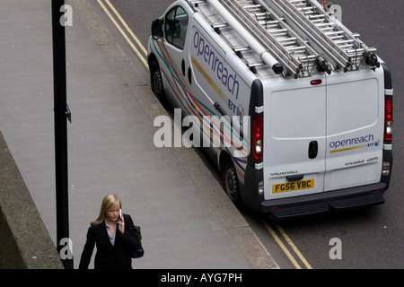 Camionnette BT Openreach avec un utilisateur de téléphone mobile passant devant Banque D'Images