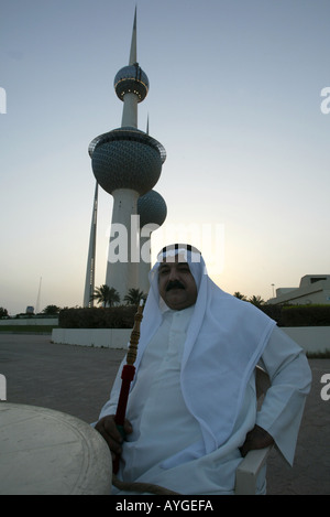 Un homme fume un narguilé traditionnel habillé en Thaubs au Kuwait Towers observation deck restaurant et châteaux d'eau. Banque D'Images