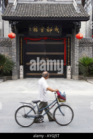 Vélo Cycliste poussant passé portique traditionnel, Chengdu, Chine Banque D'Images