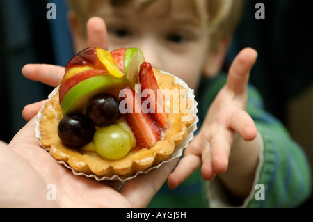 Un jeune garçon atteint d'une tarte aux fruits Banque D'Images