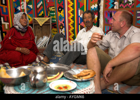 Visiteur assis sur marbre coin avec une famille berbère troglodytique souterrain accueil tunisie matmata Banque D'Images