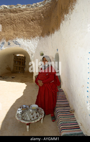 Femme en souterrain troglodytique berbère Accueil s'abrite à l'ombre de la chaleur féroce Tunisie Matmata Banque D'Images