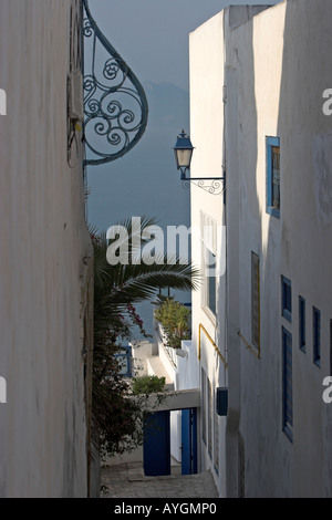 Allée raide entre les maisons blanchies à la chaux avec lampe et fenêtre auvent Sidi Bou Said Tunisie village
