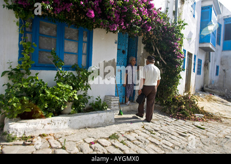 L'homme parle de femme âgée en porte Sidi Bou Said Tunisie village Banque D'Images