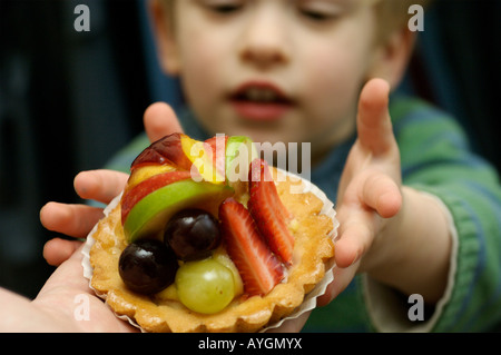 Un jeune garçon atteint d'une tarte aux fruits Banque D'Images