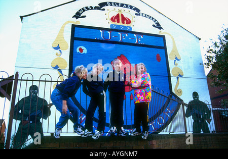 Les enfants de la rue jouant murales loyalistes .sur les rues de Shankhill Road illustrant les luttes paramilitaires, l'Ouest de Belfast Banque D'Images