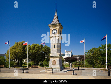 Tour de l'horloge avec drapeaux nationaux derrière sur la promenade de front de mer à Exmouth, Devon Banque D'Images