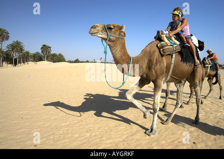 Femme et enfant randonnée chamelière dans le désert du Sahara, près de Douz Tunisie Banque D'Images