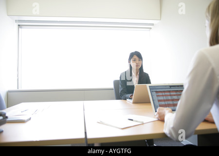 Deux businessman avec des ordinateurs portables par table in office Banque D'Images