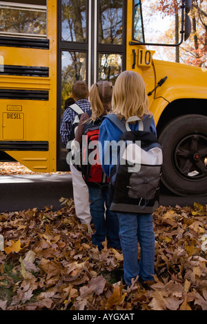 Les enfants en ligne pour les autobus scolaires Banque D'Images