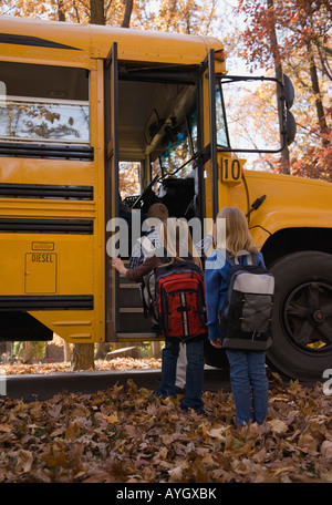 Les enfants de monter dans le bus scolaire Banque D'Images