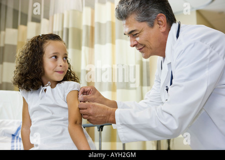 Médecin homme bandage girl's arm Banque D'Images