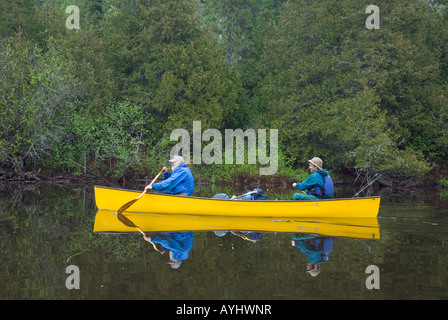 Père et fils jaune Pagaie canoë en rivière Banque D'Images