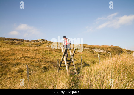 CAPEL CURIG CONWY DANS LE NORD DU PAYS DE GALLES UK Femelle Septembre escalade walker un stile haut au-dessus de Capel Curig sur Cefn y Capel Banque D'Images