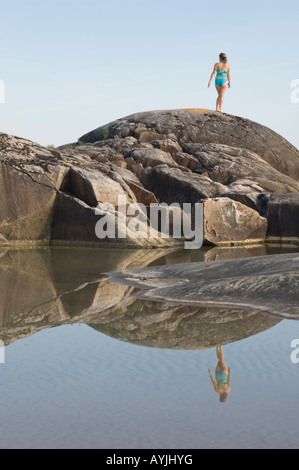 Femme ET CHIEN SUR ROCK LE LONG DES RIVES DU LAC SUPÉRIEUR DANS LE NORD DE L'ONTARIO Banque D'Images