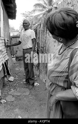 B/W d'une femme visiteur des services sociaux et un homme âgé détité vivant dans la partie la plus pauvre de la ville espagnole. Jamaïque Banque D'Images