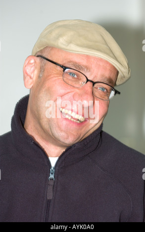 Portrait of man wearing glasses et cap laughing Banque D'Images