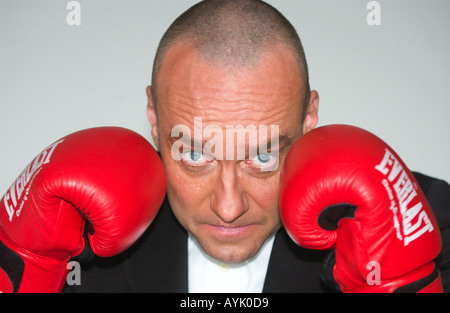 Homme chauve dans son 40s portant un costume noir n'est élever red boxing gloves Banque D'Images