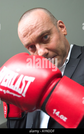 Homme chauve dans son 40s portant un costume noir n'est élever red boxing gloves Banque D'Images