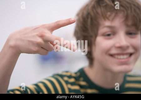 Teenage boy fait un geste drôle Banque D'Images