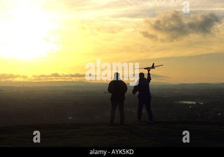 Les hommes battant modèle radio-commandé glider, Burton Dassett Hills, Warwickshire, England, UK Banque D'Images