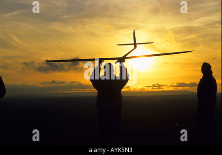 Les hommes battant modèle radio-commandé glider, Burton Dassett Hills, Warwickshire, England, UK Banque D'Images