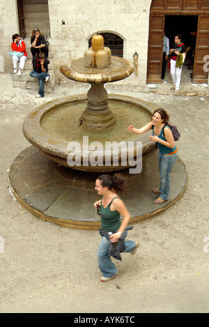 Les touristes courir autour de la fontaine des fous trois fois Gubbio portrait vertical vertical Banque D'Images