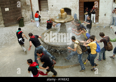 Les touristes courir autour de la fontaine des fous trois fois Gubbio Banque D'Images