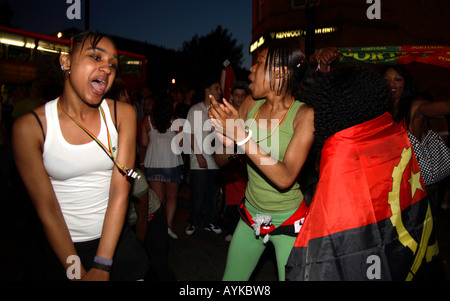 Les fans angolais dansent dans la rue après leur défaite de 1-0 contre le Portugal lors de la finale de la coupe du monde de 2006, Estrela Restaurant, Londres Banque D'Images