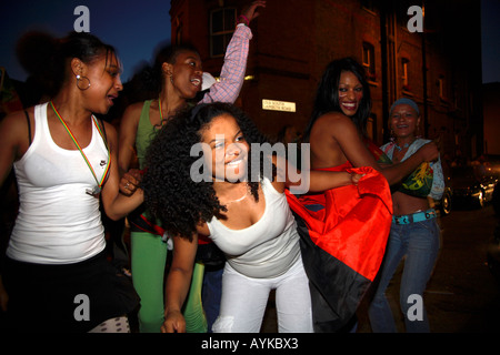 Les fans angolais dansent dans la rue après leur défaite de 1-0 contre le Portugal lors de la finale de la coupe du monde de 2006, Estrela Restaurant, Londres Banque D'Images