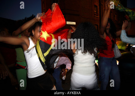 Les fans angolais dansent dans la rue après leur défaite de 1-0 contre le Portugal lors de la finale de la coupe du monde de 2006, Estrela Restaurant, Londres Banque D'Images