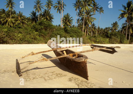 Pirogue tiré vers le haut sur la plage à Mangapwani sur la côte ouest de l'île de Zanzibar, Tanzanie Banque D'Images