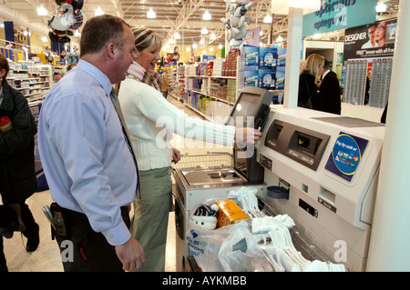 Client en utilisant un self service commander dans un supermarché Banque D'Images