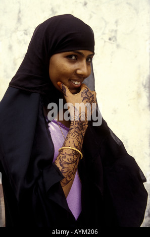 Jeune femme de l'île de Lamu, le port de la buibui noir traditionnel pour la tête la côte du Kenya Afrique de l'Est Banque D'Images