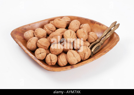 Ensemble de noix dans bol en bois avec le cassenoix laiton Banque D'Images