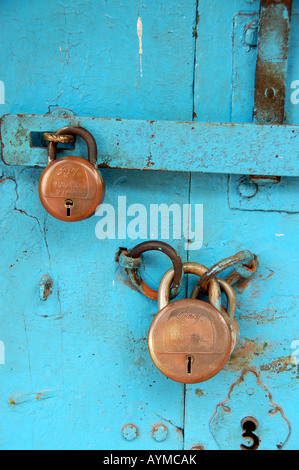 Cadenas en laiton deux sur une porte en bois turquoise Banque D'Images