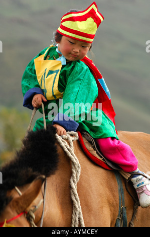 Fille de 4 ans à cheval participant à la course de chevaux du festival Naadam, Oulan-Bator, Mongolie Banque D'Images