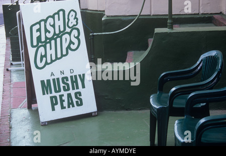 Sandwich vert et blanc publicité conseil fish and chips et petits pois vert sur le coin salon avec des chaises vertes Banque D'Images