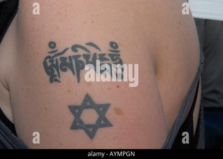 Jeune femme avec tatouage tibétain judaïque et marque sur son bras Banque D'Images
