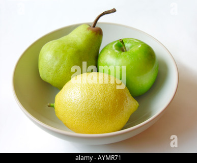 Poire citron et pomme dans un bol blanc lave Banque D'Images