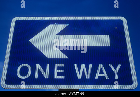 Close up de bleu et blanc roadsign sous ciel voilé ciel bleu avec la flèche pointant vers la gauche, et indiquant une façon Banque D'Images