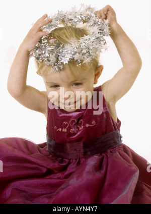 Baby Girl wearing a party dress mettant un halo tinse sur sa tête Banque D'Images